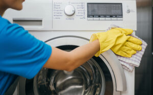 housewife hand protective glove cleans washing machine emphasizing regular cleanup house hygiene cleaner work glove hygiene routine clean washing machine maid cleaning service 1