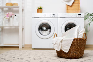 modern laundry room with white appliances greenery