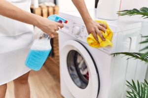 young hispanic woman cleaning washing machine laundry room 1
