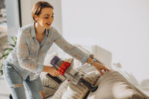 young woman with rechargeable vacuum cleaner cleaning home 3