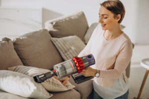 young woman with rechargeable vacuum cleaner cleaning home 5